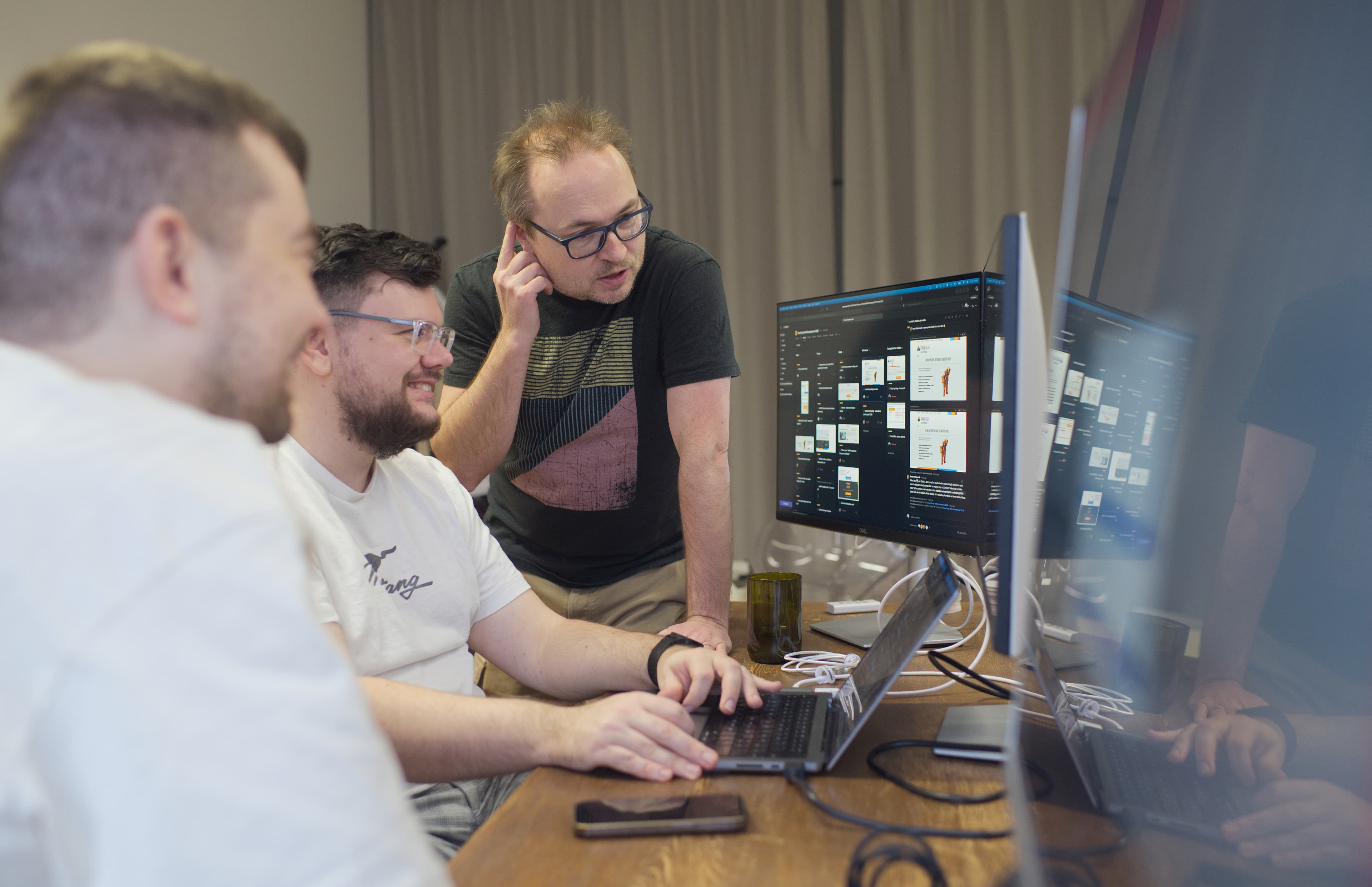 Tým Atlantic společně konzultuje návrh webu u počítačů